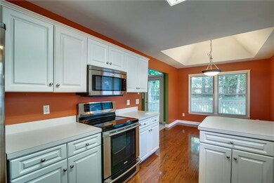 THE KITCHEN IS LIGHT AND BRIGHT WITH WHITE CABINETRY AND IS REPLETE WITH A STAINLESS STEEL APPLIANCE PACKAGE.