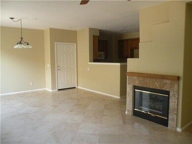 SPACIOUS LIVING AREA FEATURES LOVELY TILED FIREPLACE, UPGRADED FLOORING, SLIDER EXIT TO REAR PATIO & FRESH PAINT