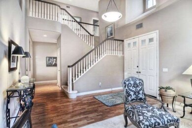 Gleaming wood flooring and a dramatic staircase ar
