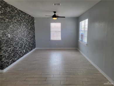 Unfurnished room featuring ceiling fan, baseboards, and light wood-style flooring