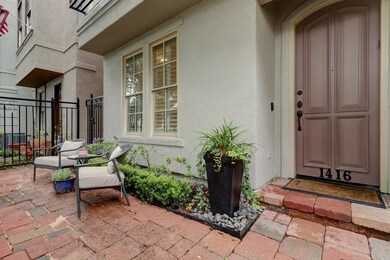 Gated front yard features a brick paver walkway an