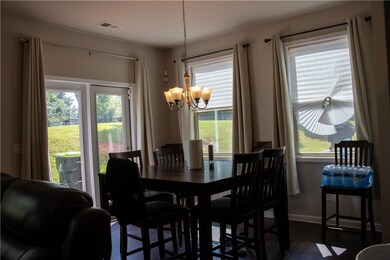 Dining area with a chandelier, plenty of natural light, and dark wood-type flooring