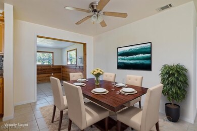 Tiled dining room with ceiling fan and wooden wall
