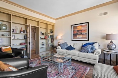 Living room featuring ornamental molding, built in
