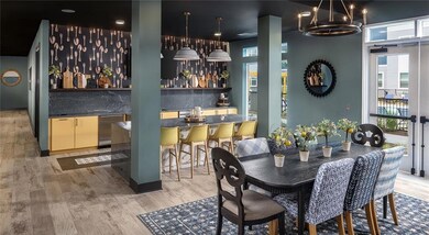 Dining room with wet bar, light wood finished floors, and a chandelier