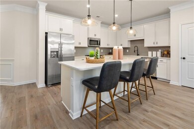 Kitchen featuring white cabinetry, light counterto