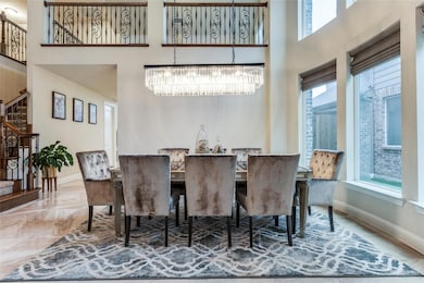 Dining area with a high ceiling, tile flooring, a healthy amount of sunlight, and a chandelier