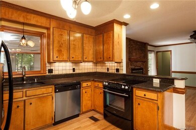 Kitchen has granite and tile backsplash, black/sta