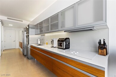 Kitchen with visible vents, a sink, under cabinet range hood, and gray cabinetry