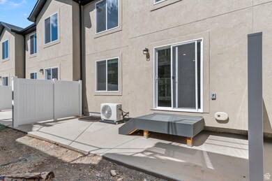 Rear view of house with stucco siding and a patio area