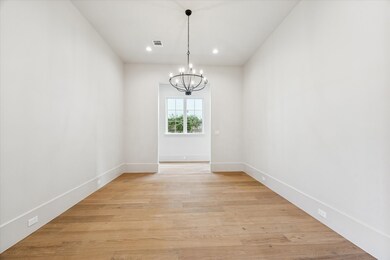 A view of the dining room looking towards the back gallery that extends from the mud room off the garage to the butler's pantry. Engineered hardwood floors throughout the living areas and bedrooms.