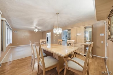 Dining area featuring a chandelier, light wood-style flooring, and ceiling fan