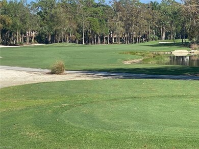 View of property's community featuring view of golf course, view of wooded area, and a yard