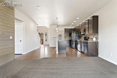 Kitchen with dark brown cabinetry, tasteful backsp