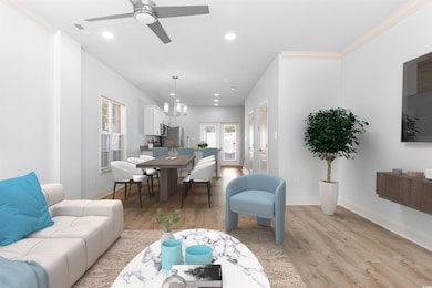 Living room with ceiling fan with notable chandeli