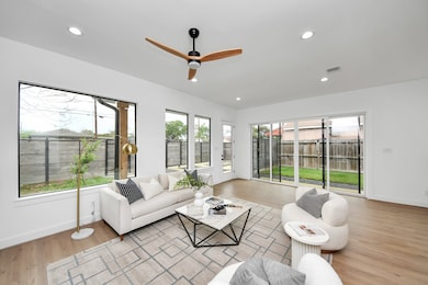 The living room has large windows, ceiling fan, re