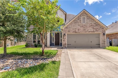 View of front of property with brick siding, concrete driveway, and a front yard