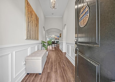 Entrance foyer featuring arched walkways, ornamental molding and chandelier