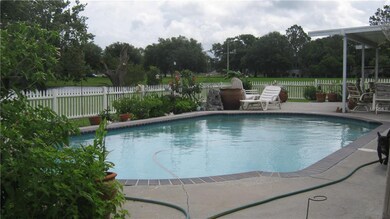 POOL VIEW WITH SIDE COVERED PORCH.  BEAUTIFUL LAND