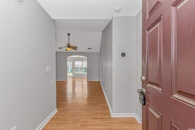 Entryway with baseboards, a ceiling fan, lofted ceiling, arched walkways, and light wood finished floors