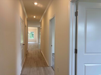 Corridor featuring ornamental molding, light wood-type flooring, recessed lighting, and baseboards