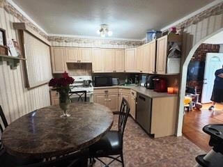 Kitchen with dishwasher, electric range, wallpapered walls, arched walkways, and ornamental molding