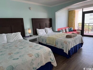 Bedroom with arched walkways, ornamental molding, access to exterior, and wood finished floors