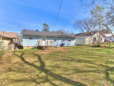 Rear view of property with crawl space and a shingled roof