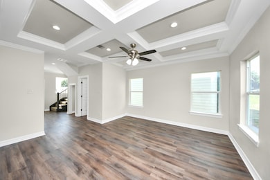 The family room offers a bright and inviting atmosphere, highlighted by durable LVP flooring, recessed lighting, and an elegant tray ceiling for added architectural detail. Expansive windows fill the space with natural light, creating a warm and welcoming environment perfect for everyday living - (representation photo).