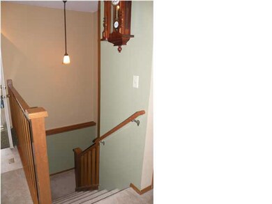 Stairway with landing leading to basement