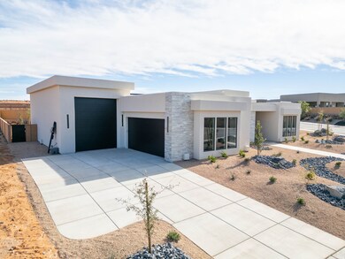 Modern home with stone siding, stucco siding, driveway, and a garage