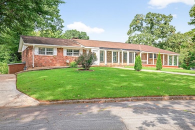Single story home featuring brick siding and a front lawn
