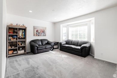 Living area with carpet floors and recessed lighting