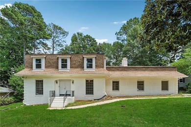 View of property featuring roof with shingles and brick siding