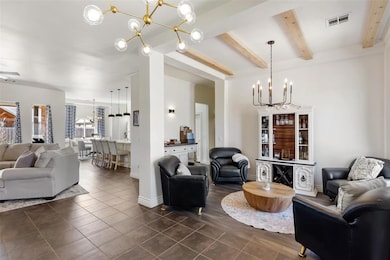 Living room featuring baseboards, a chandelier, vi