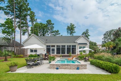 Back of house featuring a patio area, a hot tub, a