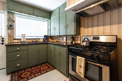 Kitchen featuring gas stove, wall chimney exhaust