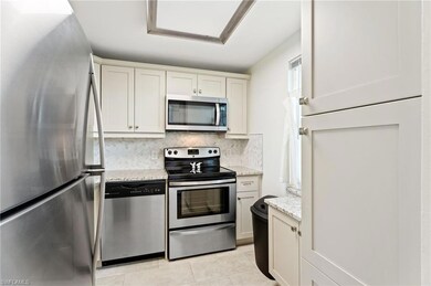 Kitchen with tasteful backsplash, light stone coun