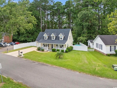Cape cod-style house featuring covered porch and driveway