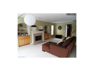 The great room has a gas fireplace with a tile  su