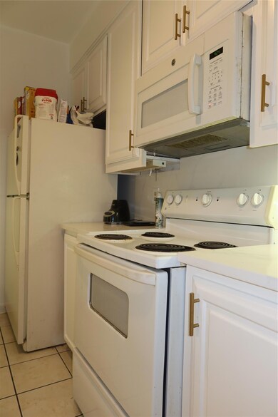 Kitchen featuring stove, light tile patterned flo