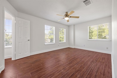 Spare room featuring dark wood-style flooring and ceiling fan