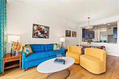 Living room with ornamental molding and light wood