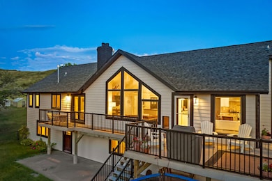 Rear view of house featuring a chimney, a shingled roof, an attached garage, and a patio