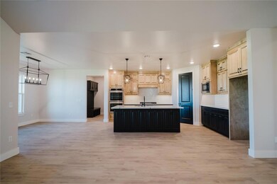 Kitchen featuring a center island with sink, light