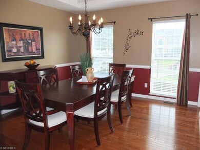 Spacious dining room with hardwood flooring and ch