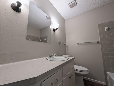 Full bathroom featuring toilet, a textured ceilin