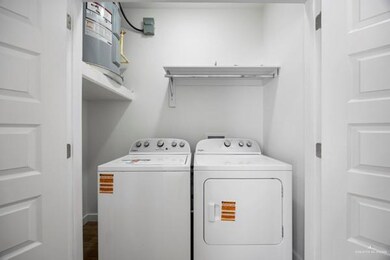 Laundry room featuring washing machine and dryer and dark wood-type flooring