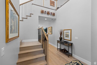 Stairs with wood finished floors and a towering ceiling