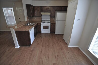 Kitchen with under cabinet range hood, a sink, wh